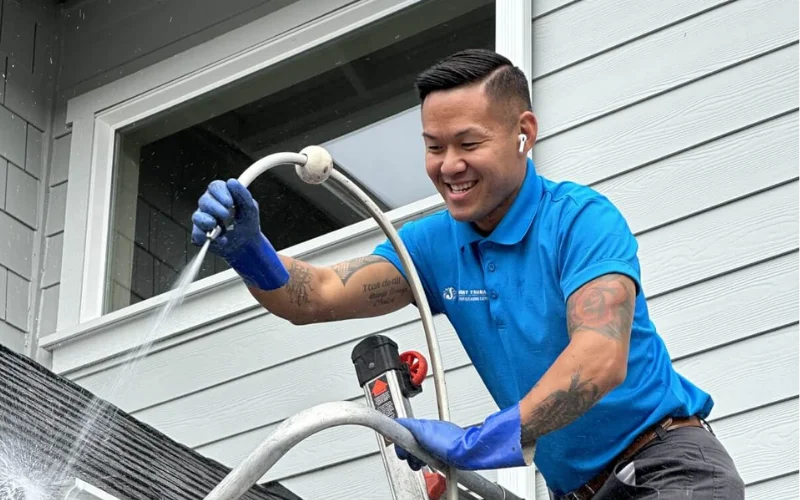 Professional gutter cleaning technician clearing gutters