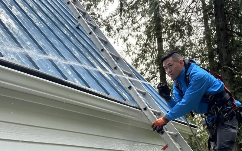 Exterior cleaning technician performing roof cleaning