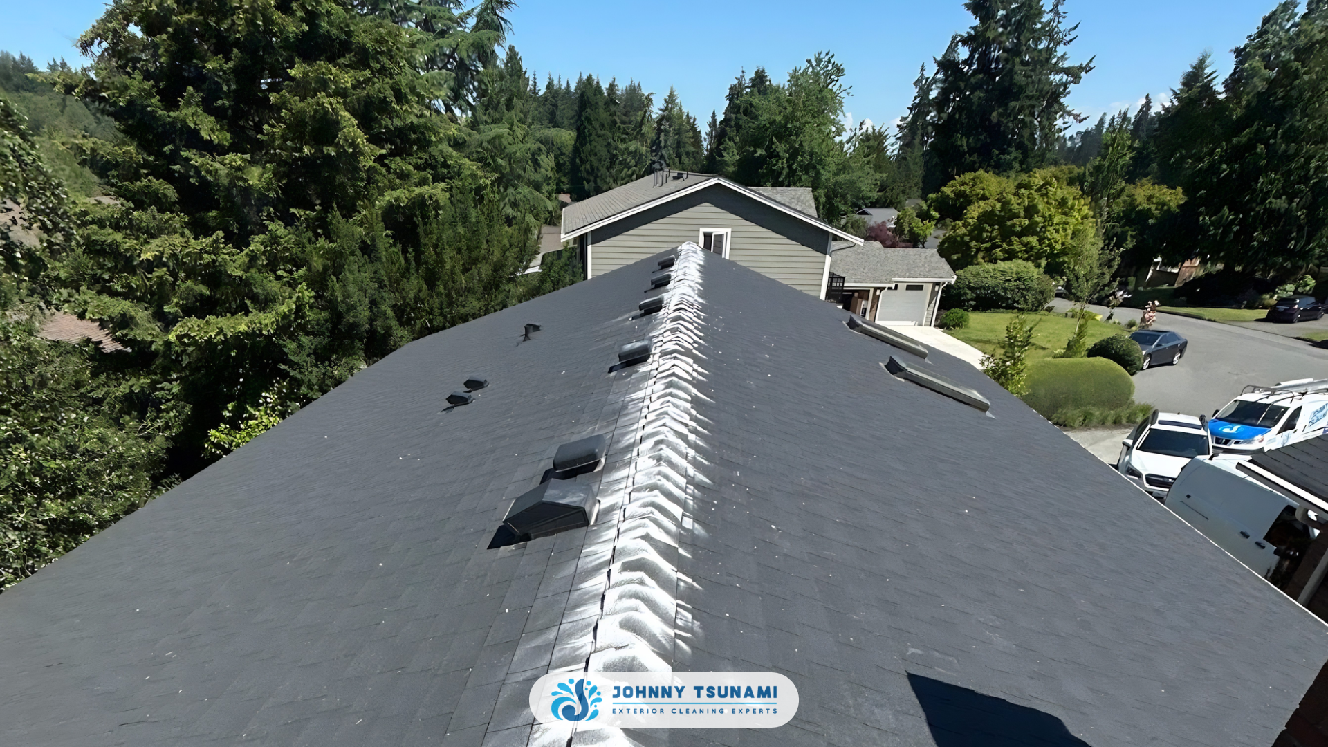 Johnny Tsunami technician soft washing a shaded PNW roof to treat moss in summer