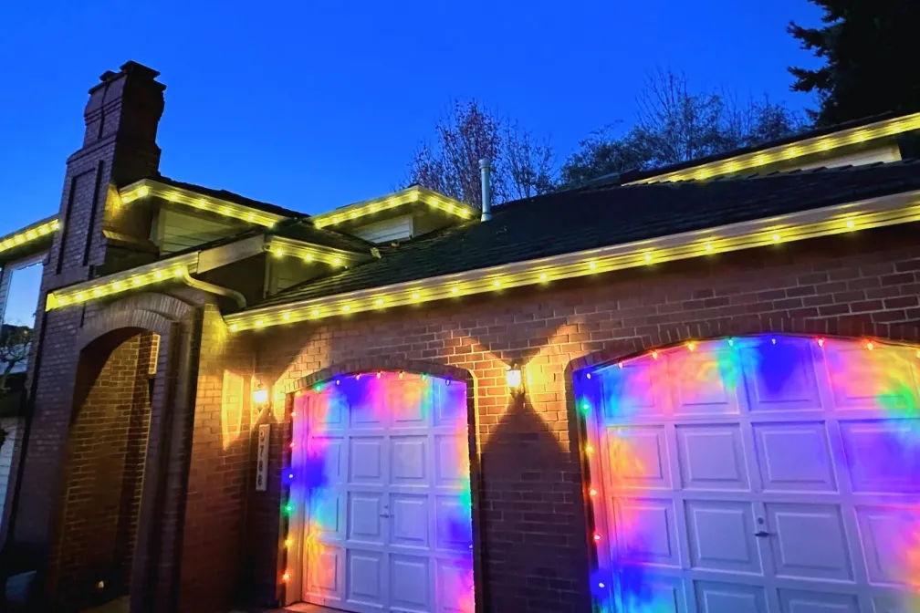 Colorful garage and roofline holiday lighting display