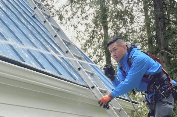 Professional removing leaves and debris from residential gutters