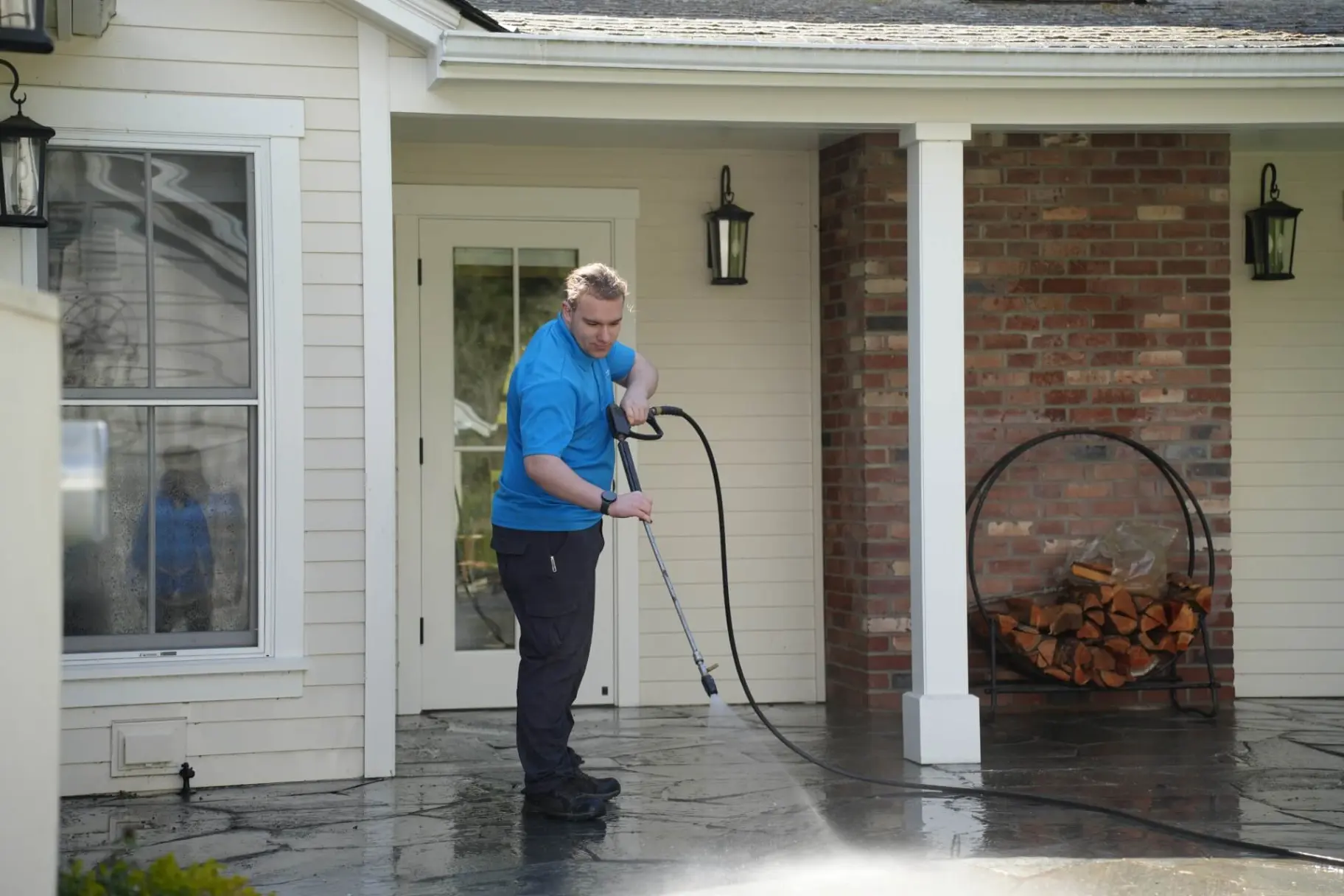 Professional technician soft washing a home exterior