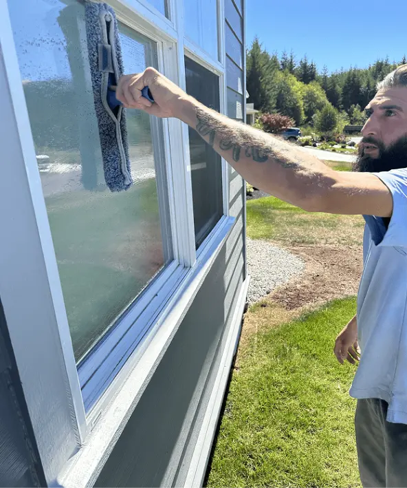 Professional window cleaner washing exterior glass surfaces