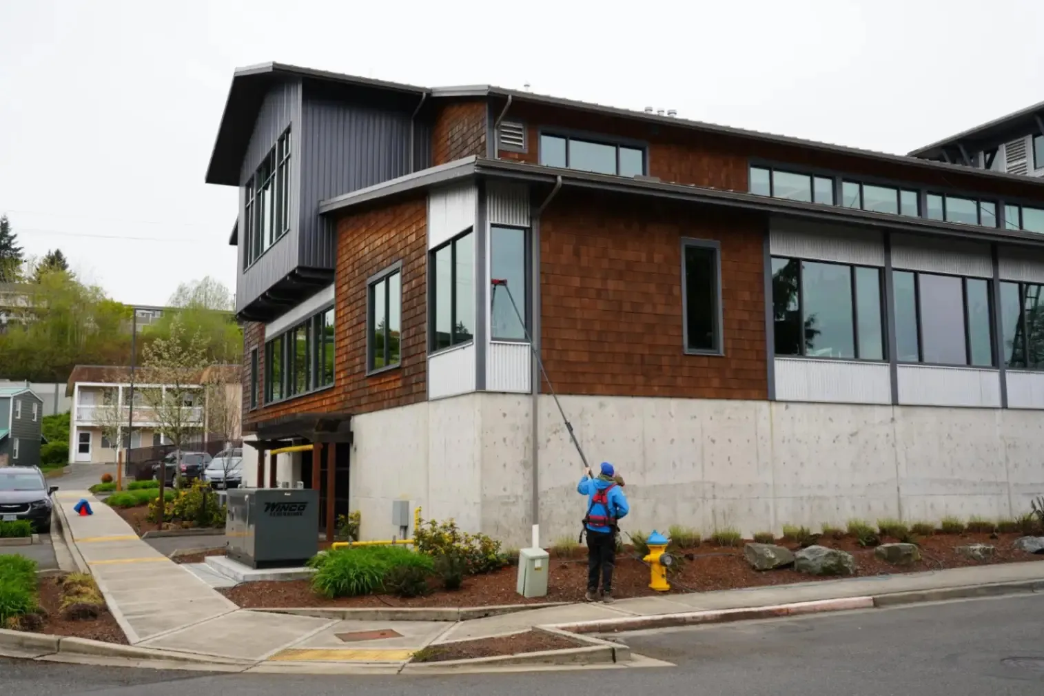 Professional cleaning of hard-to-reach upper-story windows using specialized equipment