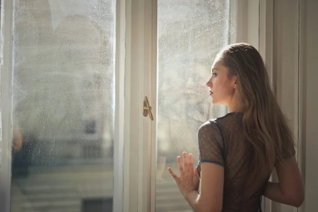 Homeowner looking through clean residential windows after professional cleaning